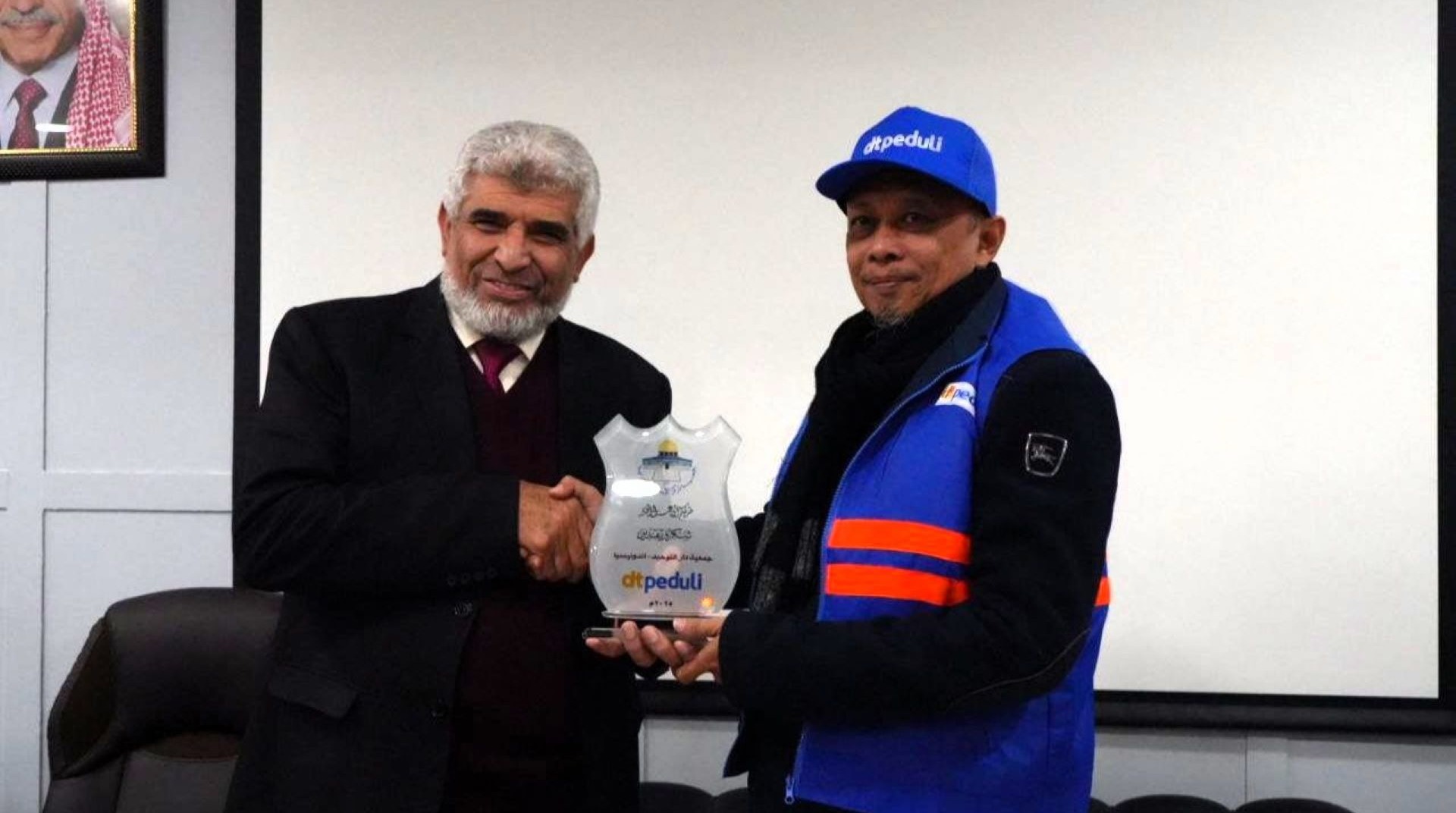 Jabeer, Director of ICCS, presenting an award plaque to a DT Peduli representative.