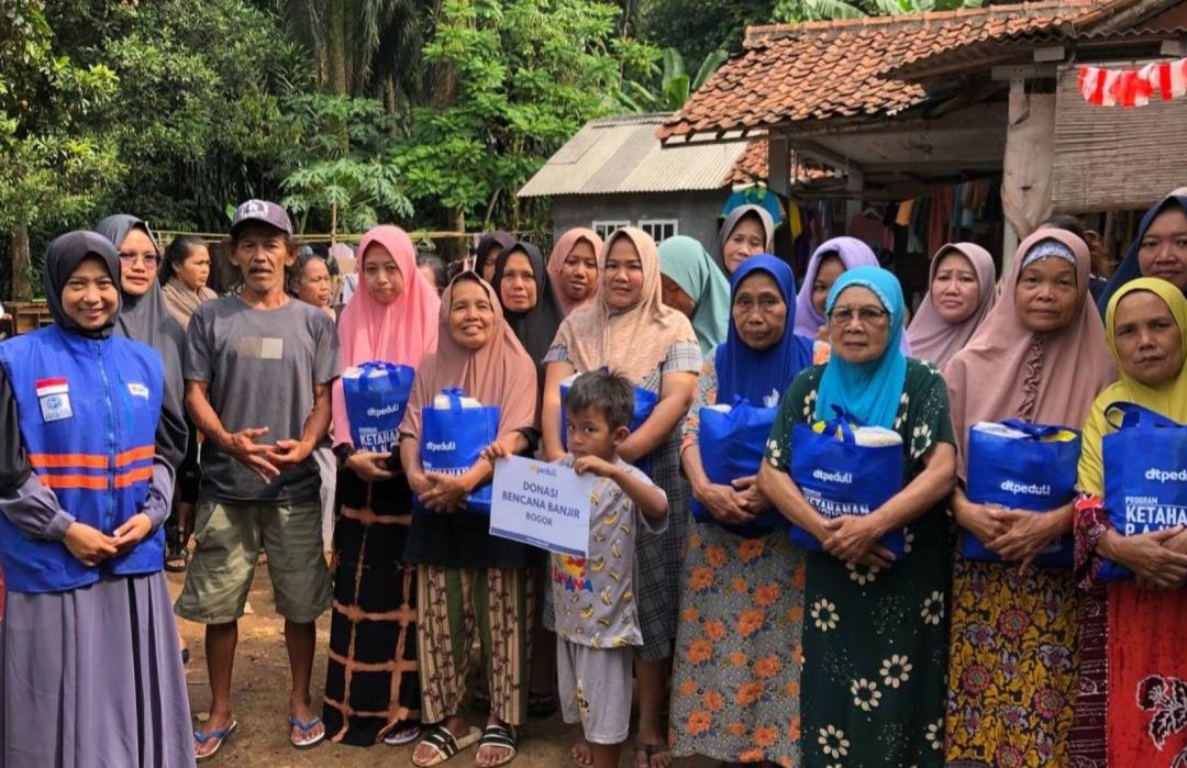 DT Peduli volunteers distributing food packages to flood victims in Cimulang Village.