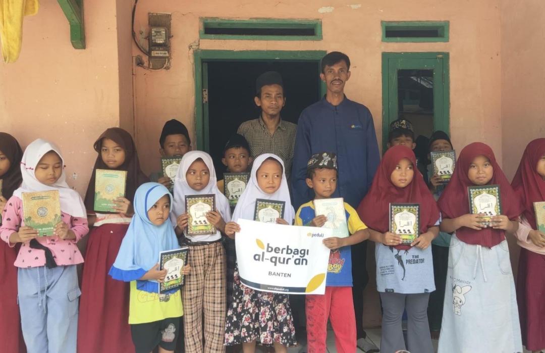 Students at TPQ Al-Ikhlas Cileles receiving new Qur'ans and Iqra books.